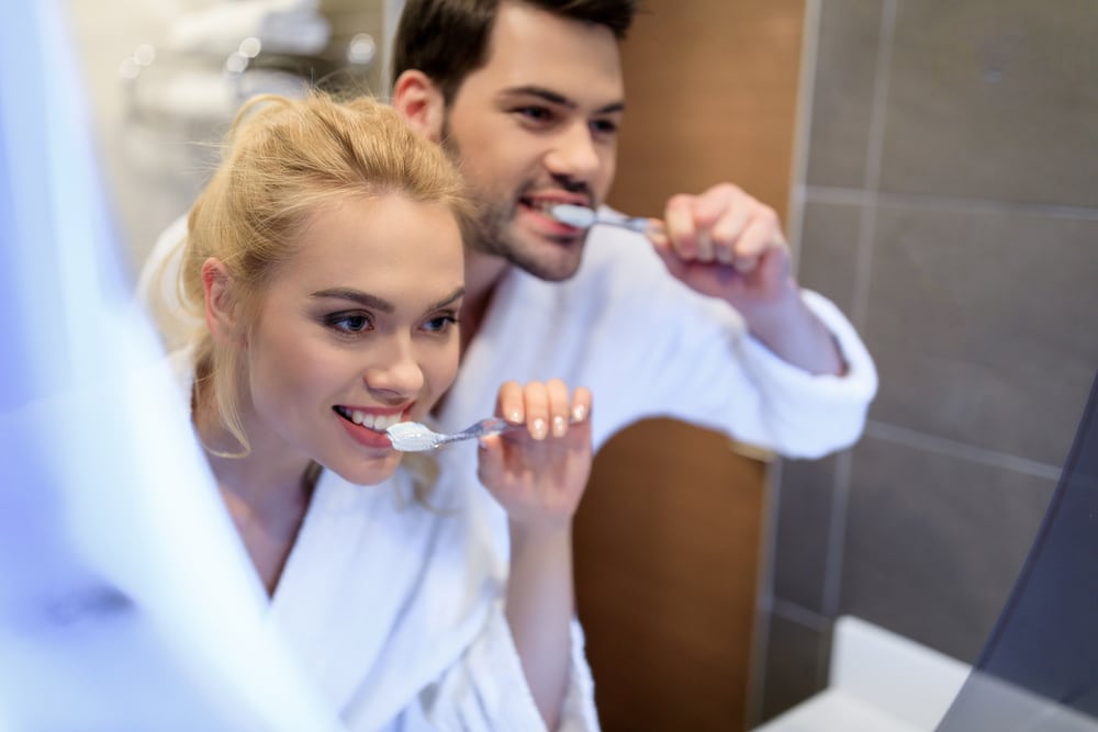 brushing teeth in the kitchen sink